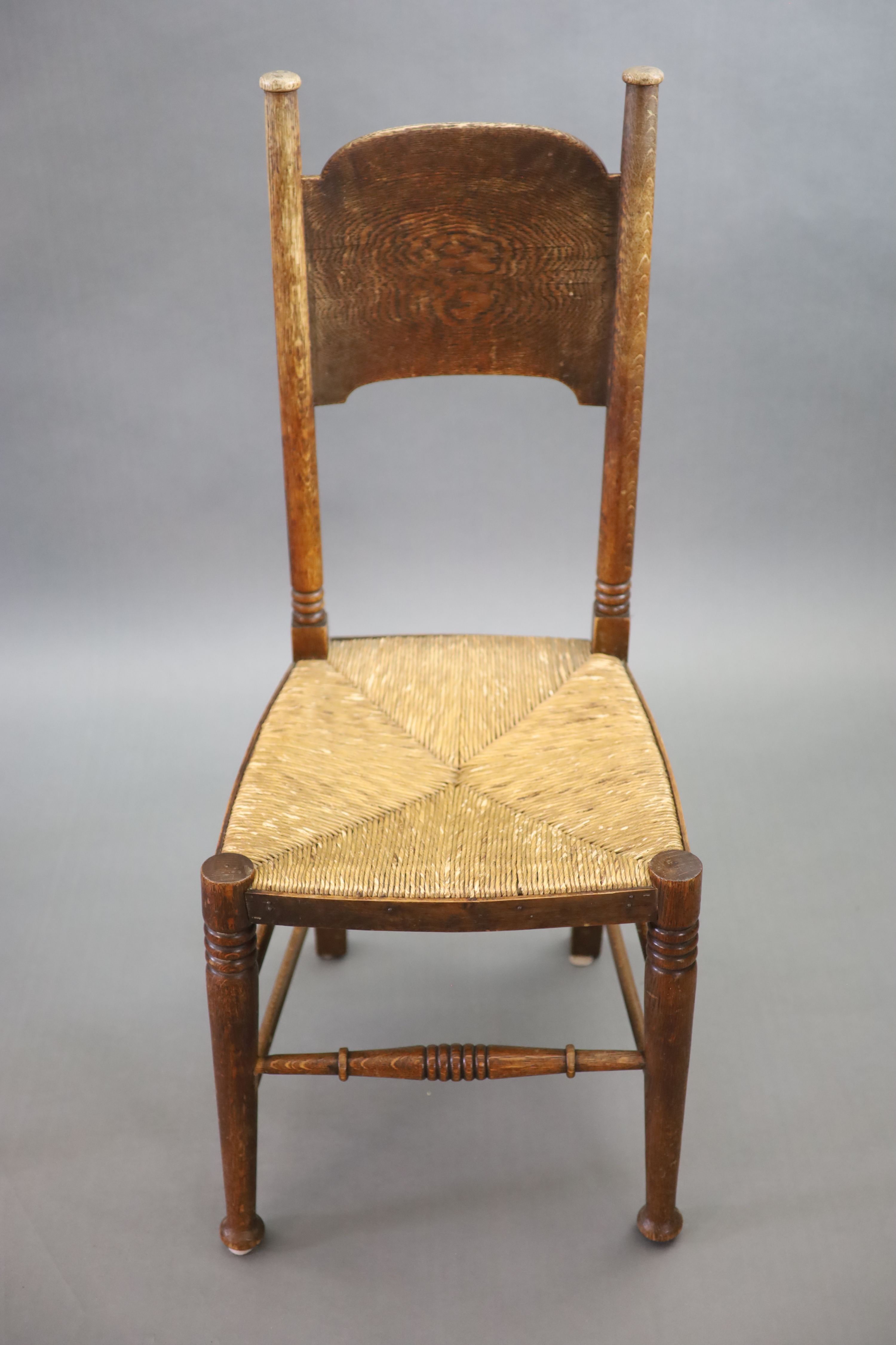 A set of six Arts & Crafts oak chairs, including a pair of carvers, in the Glasgow School manner by William Birch, High Wycombe, carvers W.58cm D.54cm H.109cm